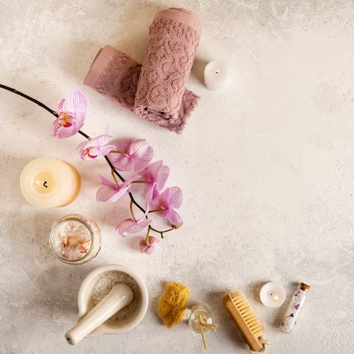 Ayurvedic spa ingredients with towel, candle, and brush on display.